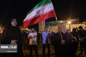 مرد مسنی پرچم کشورمان را در مراسم‌شام غریبان شهدای خدمت به دوش گرفته است
