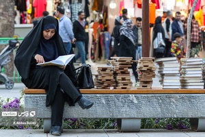 خانمی در حال قرائت قرآن در گذر تاریخی چهارباغ عباسی است