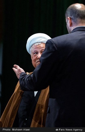 یکی از محافظان در حال راهنمایی آیت الله اکبر هاشمی رفسنجانی رئیس مجمع تشخیص مصلحت نظام به سمت مسیر خروج می‌باشد