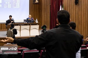 دانشجوی دانشگاه علم و صنعت در حال طرح سوال خود از علیرضا زاکانی شهردار تهران‌ است.