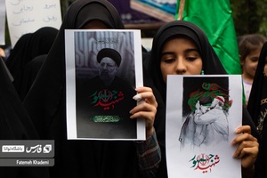 دو بانو که عکس شهید جمهور را در مراسم شهادت آیت الله رئیسی در دست داشتند