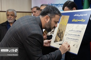 علیرضا طاهری رئیس دانشکده خبرگزاری فارس پوستر کتاب «بی چتر زیر باران» امضا میکند