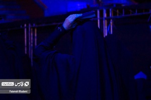 خانمی که در حال قرآن به سر گرفتن است