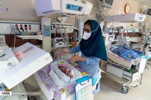 پرستار بخش مراقبت های ویژه نوزادان ( NICU 4 ) کلاهک اکسیژن را روی قفسه سینه و سر نوزاد قل چهارم (  قل D  )  قرار می دهد.