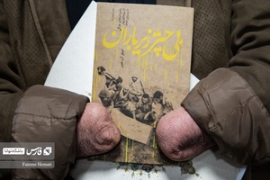 کتاب بی چتر زیر باران  در  دستان حاج علی فریدونی جانباز 8 سال دفاع مقدس قرار دارد