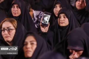 دختری عکس شهید رئیسی را در گوشی خود نشان‌میدهد