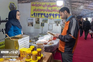 فروشنده عسل در حال توضیح دادن محصول خود به خریدار میباشد