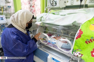 مادر قل یکم (  قل A  ) دختر را در بخش مراقبت های ویژه نوزادان (  NICU 1 ) از پشت دستگاه انکوباتور به نوزادش نگاه می کند./ بیمارستان حضرت زینب(س) شیراز