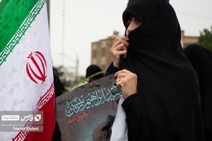 بانویی که در میدان پاستور در مراسم شهادت آیت الله رئیسی و همراهان، عکس شهید را در دست دارد و در حال گریه کردن است