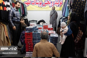 خانواده ای در حال خرید پوشاک در نمایشگاه شهرخانواده میباشد
