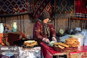 یکی از غرفه داران در حال تهیه نان محلی میباشد