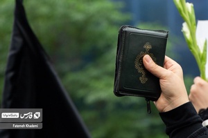 خانمی که در مراسم عزاداری شهادت آیت الله رییسی قرآن را به نشانه وحدت در دست گرفته