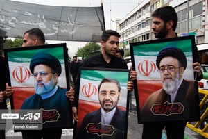 سه جوان که عکس شهید رییسی ،شهید رحمتی استاندار آذربایجان شرقی و شهیدآل هاشم امام جمعه تبریز را در دست دارند