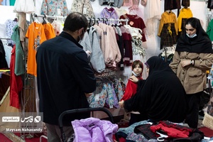 مادری در حال انتخاب کردن لباس برای دخترش در نمایشگاه شهر خانواده
