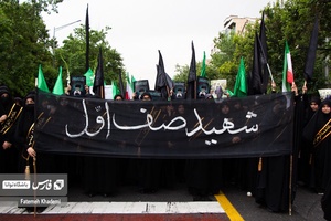 جمعیت عزادار مردم که پلاکارد شهید صف اول را در دست گرفته اند