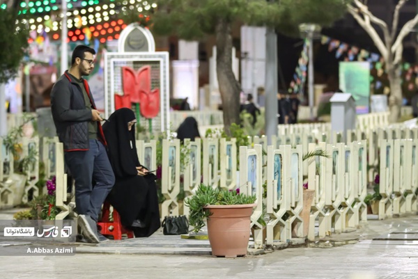 مادر و پسری در حال زیارت شهدای دفاع مقدس هستند