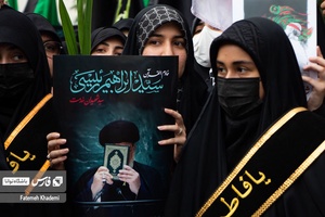 بانویی که عکس شهید آیت الله رئیسی را در دست گرفته و در مراسم عزاداری شهادت ایشان شرکت کرده است