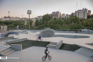 نوجوانان مشغول تمرین با دوچرخه حرکات نمایشی (BMX) در زمین اسکیت پارک آب و آتش می باشد. کودکان و نوجوانان برای ورود به این مجموعه که به صورت حرفه ای و غیر رایگان در تهران است، باید روزانه هزینه قابل توجهی پرداخت کنند.